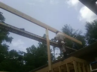Carpenter setting a ridge beam over a new addition frame — Ice Dam Removal by Roofing Brothers in Cottekill