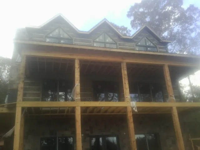 Dormers and porch framing on a large log home under construction — Roof Coating work by our crew in Cottekill