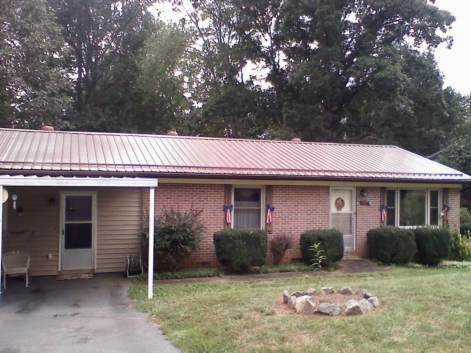 Bronze metal roof and carport on a brick ranch home — Roof Repair work by our crew in Cottekill